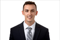 Business portrait of young man in suit with soft light and neutral background.