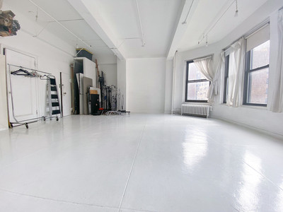 Interior of a Chelsea natural light photo studio with white floors, large windows, and open shooting space