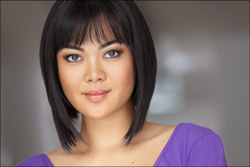 Professional NYC headshot of young Asian woman in purple, modern and confident