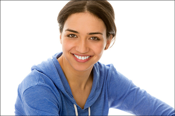 NYC commercial headshot of young woman in blue hoodie, friendly, bright, and approachable portrait.