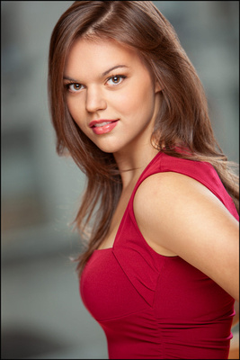 NYC actor headshot of young woman in red dress, confident expression and strong presence